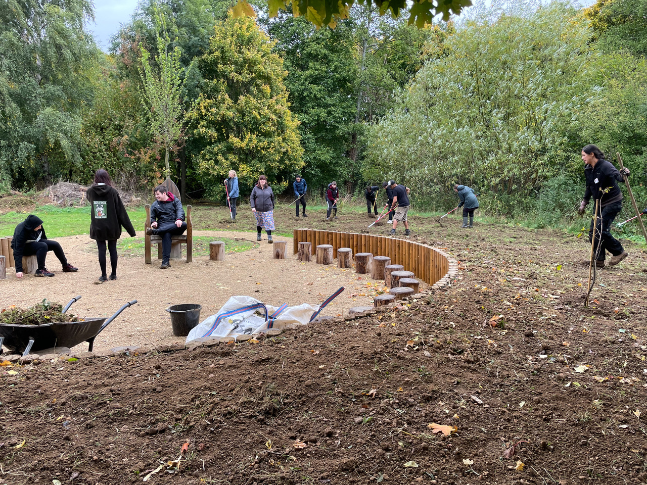 Bartholomew students raking Eynsham Primary School's meadow before seeding